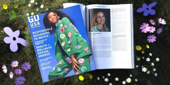 Open GDUSA magazine on grass with flowers around it