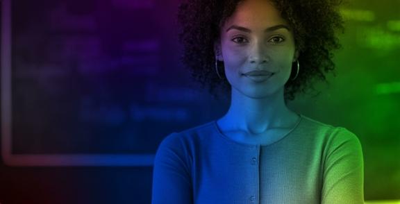 Woman standing with arms crossed under colorful lighting