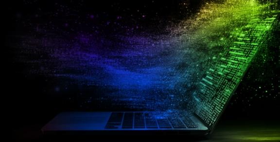 Laptop with colorful digital particles streaming from the screen