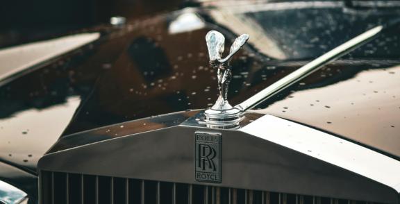Luxury2 Close-up of a Rolls-Royce hood ornament on a wet car grille