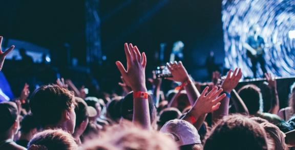 Music Entertainment 2 min Concert crowd with raised hands facing a bright stage