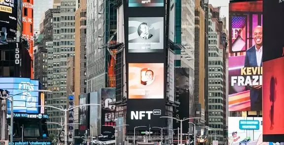 Times Square billboards displaying NFT ads among tall city buildings