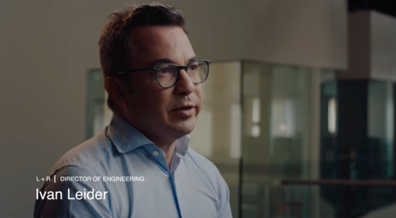 Man in glasses speaking during an interview in an office setting