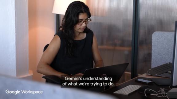 Woman working at a laptop in an office with Google Workspace caption on screen