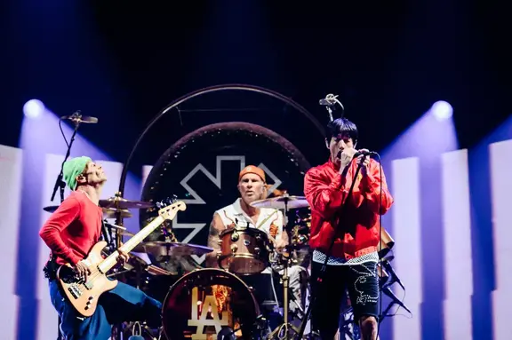 Rock band performing onstage under bright concert lights