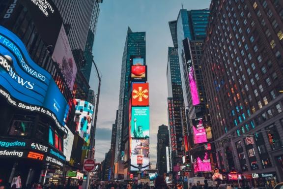 Times Square at dusk with illuminated billboards and tall buildings