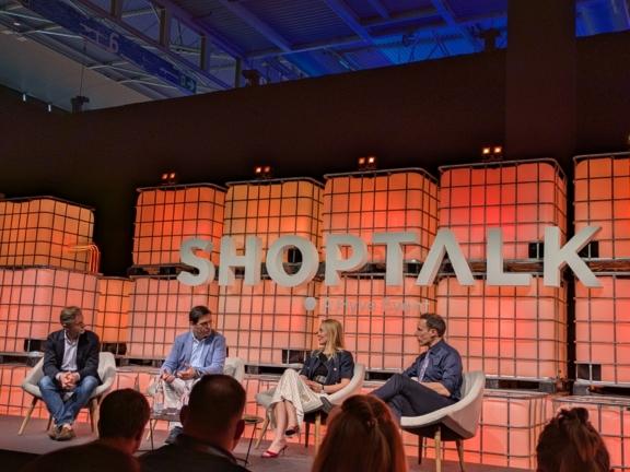 Shoptalk panel discussion on an orange lit stage