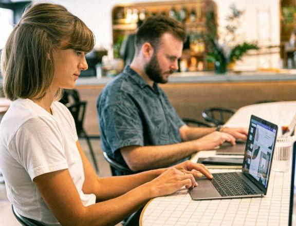 Startups Ventures 1 min Two people working on laptops at a cafe table