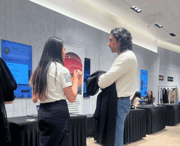 Two attendees talk at a fashion event booth