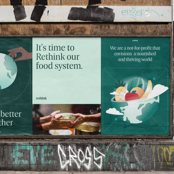 Rethink food system posters displayed on a graffiti-marked wall.