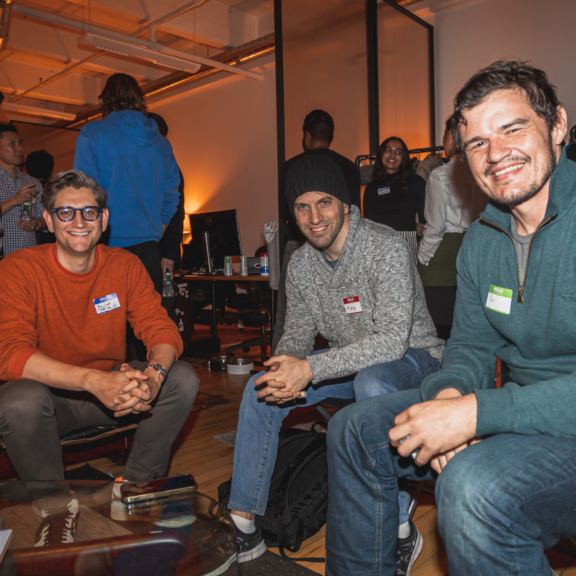 Three attendees seated at a casual networking event