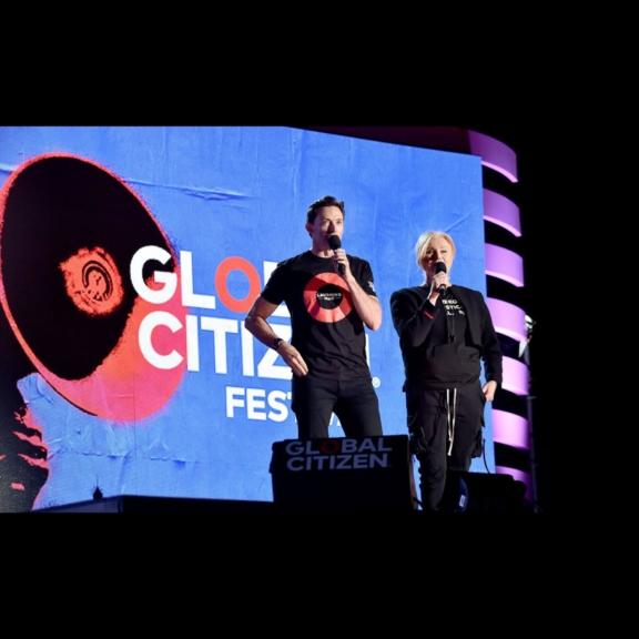 Two presenters on a Global Citizen Festival stage with microphones