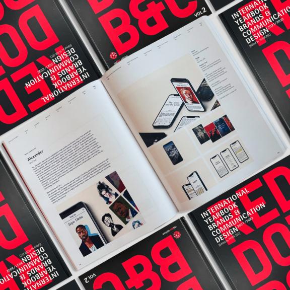 Open design book spread on top of red and black branding annuals