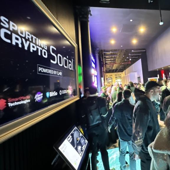 Sporting Crypto Social sign beside a crowded event hallway