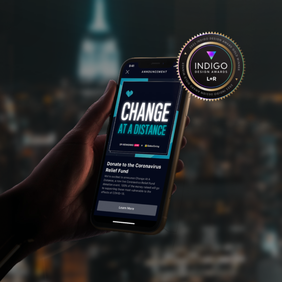 Hand holding a phone with "Change at a Distance" fundraiser screen and award badge