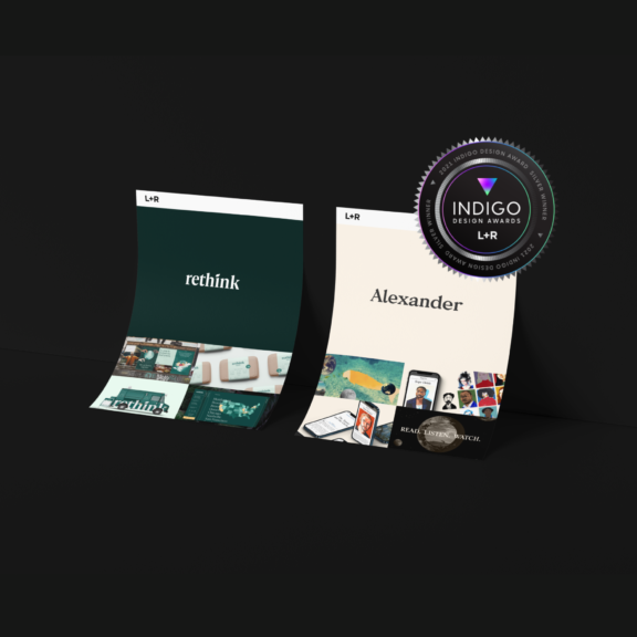 Two curled design posters with an Indigo Design Awards winner badge