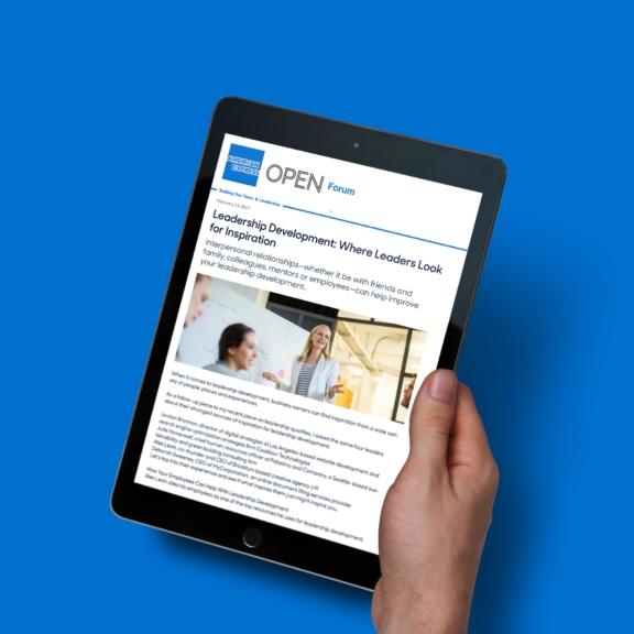 Hand holding a tablet displaying an American Express OPEN Forum article