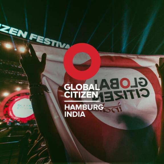 Global Citizen Hamburg India graphic over a concert flag with stage lights
