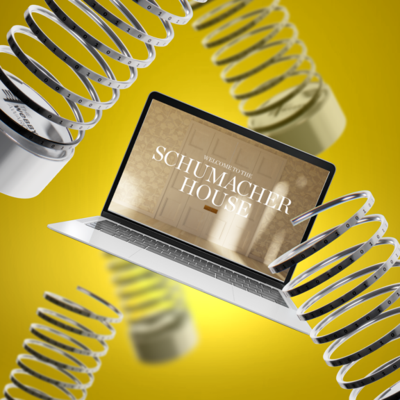 Laptop showing "Welcome to the Schumacher House" surrounded by metal springs