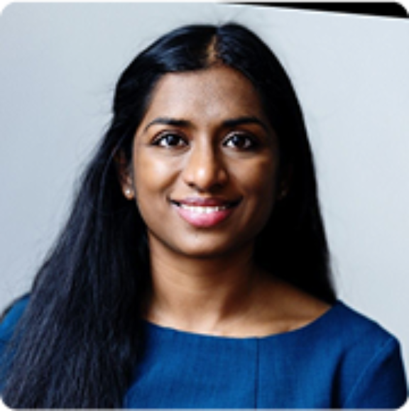 Madhavi gavini Headshot of a smiling woman with long dark hair wearing a blue top