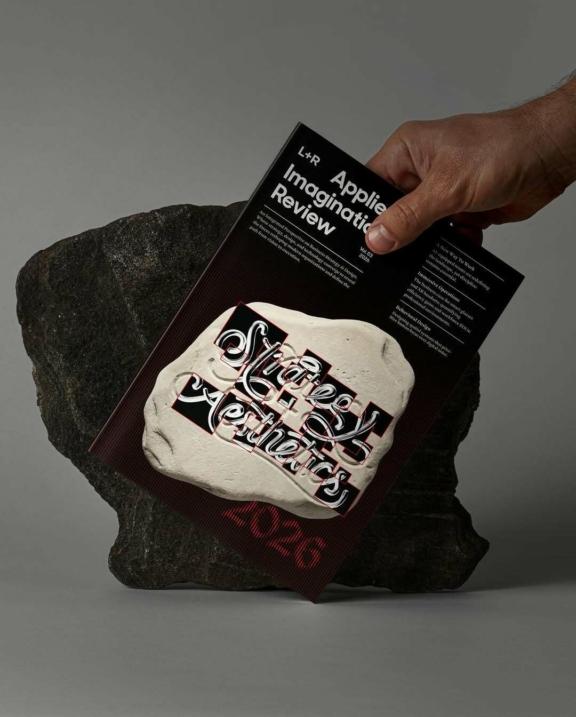 708442310 18587157721059656 1113290980857428421 n Hand placing a branded black card on a patterned tote bag beside a rock