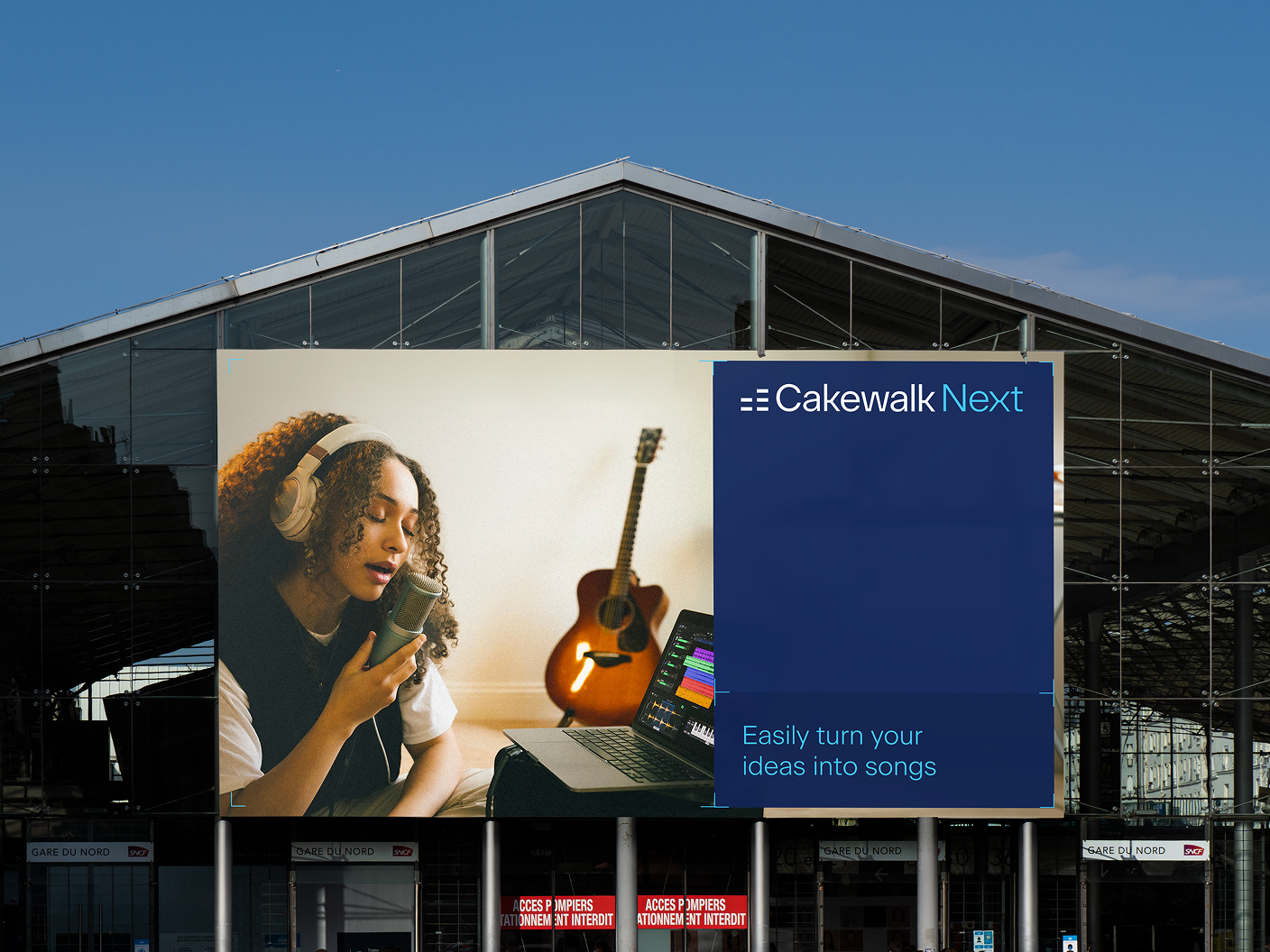 Large Cakewalk Next billboard on a glass-fronted building.