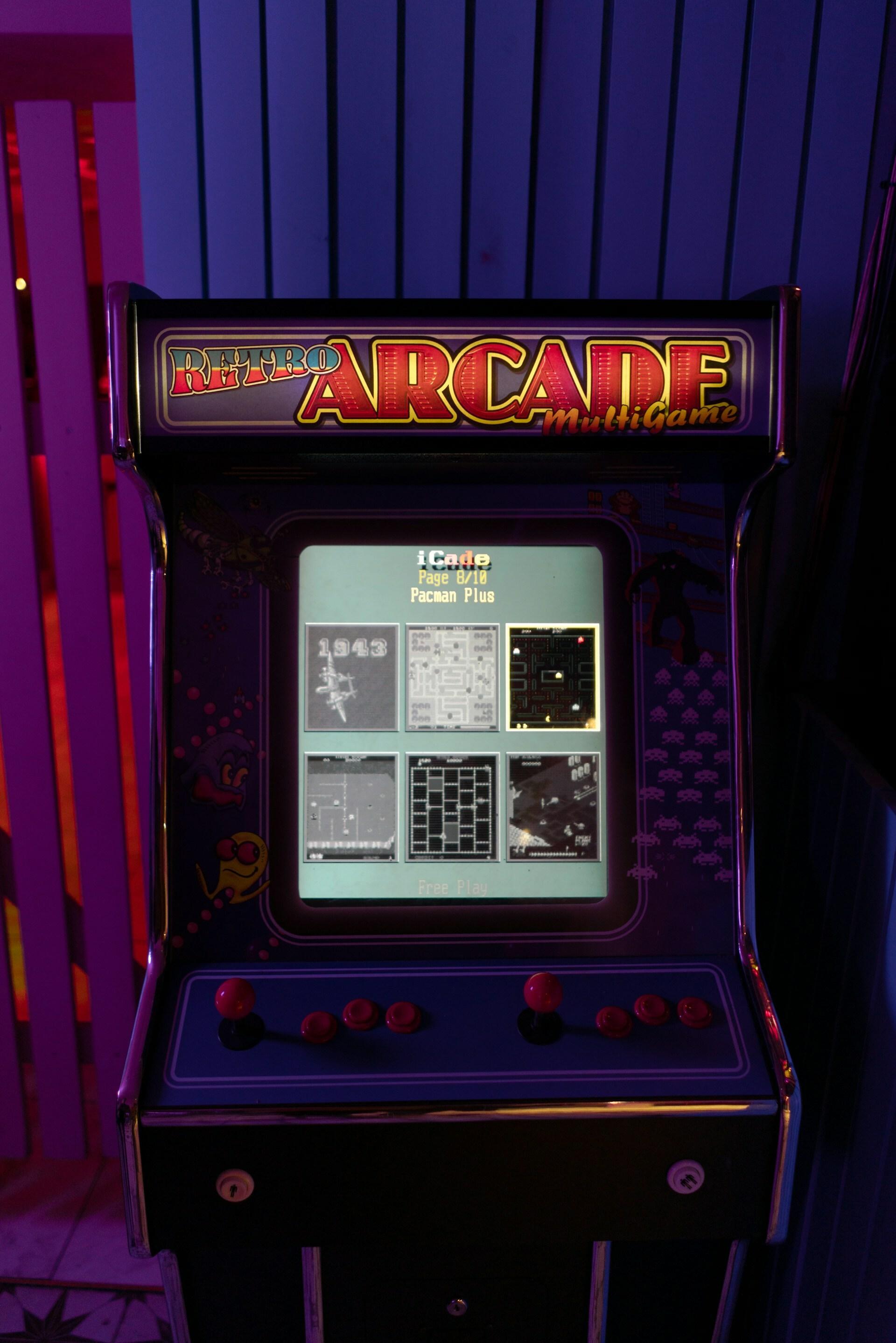 Vintage arcade cabinet lit with purple and red lights