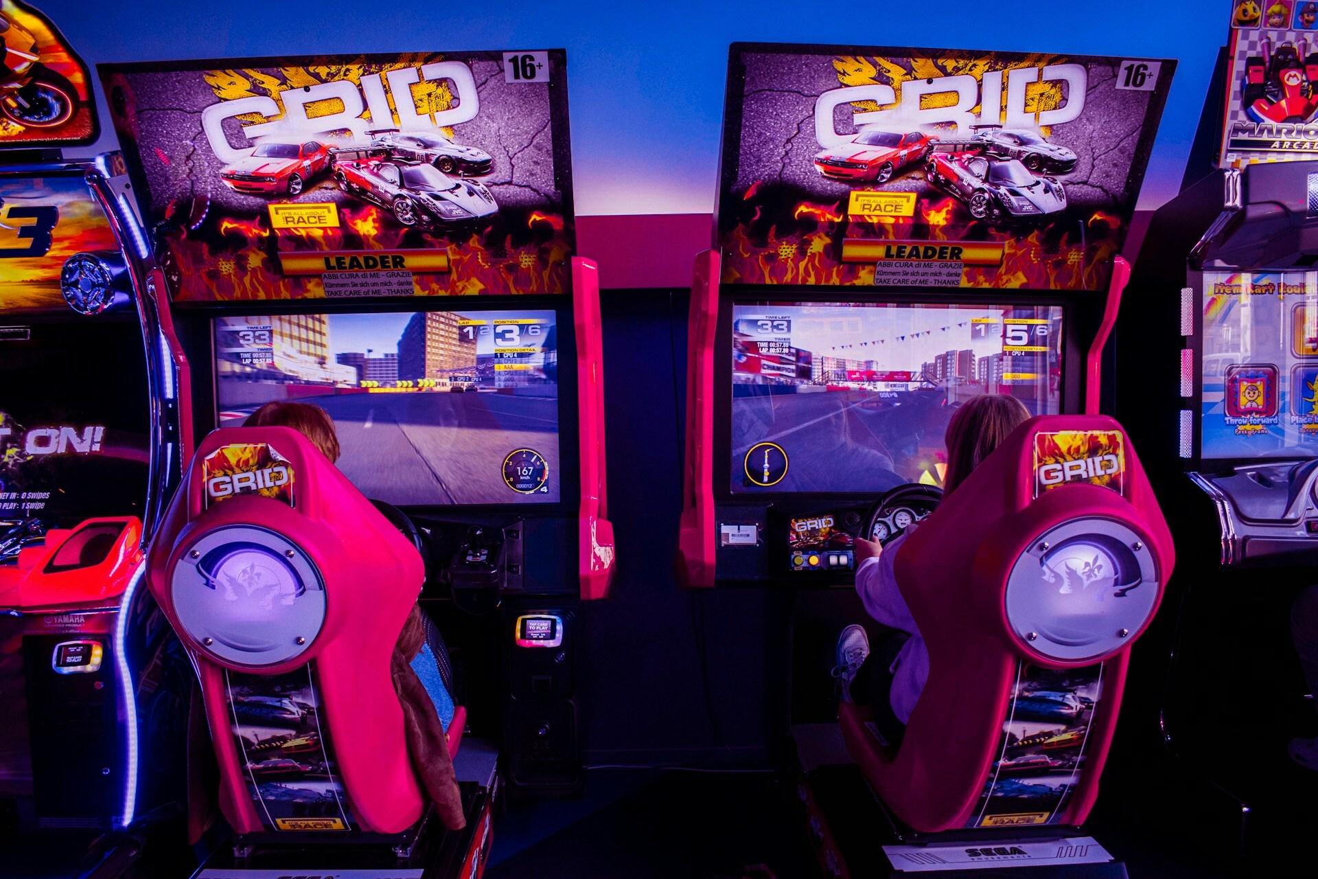 Two brightly lit arcade game machines side by side