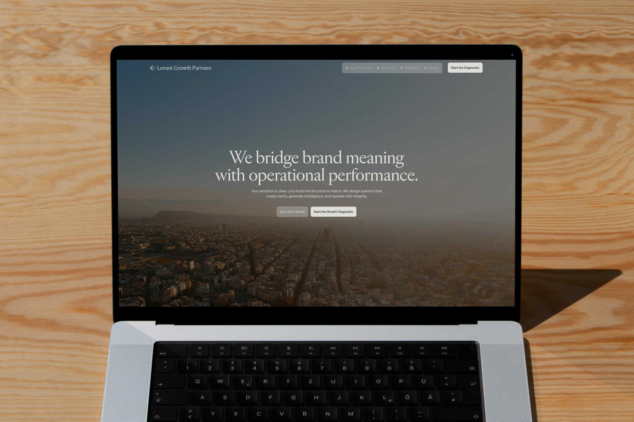 Laptop displaying the Levant Growth Partners homepage on a wooden table