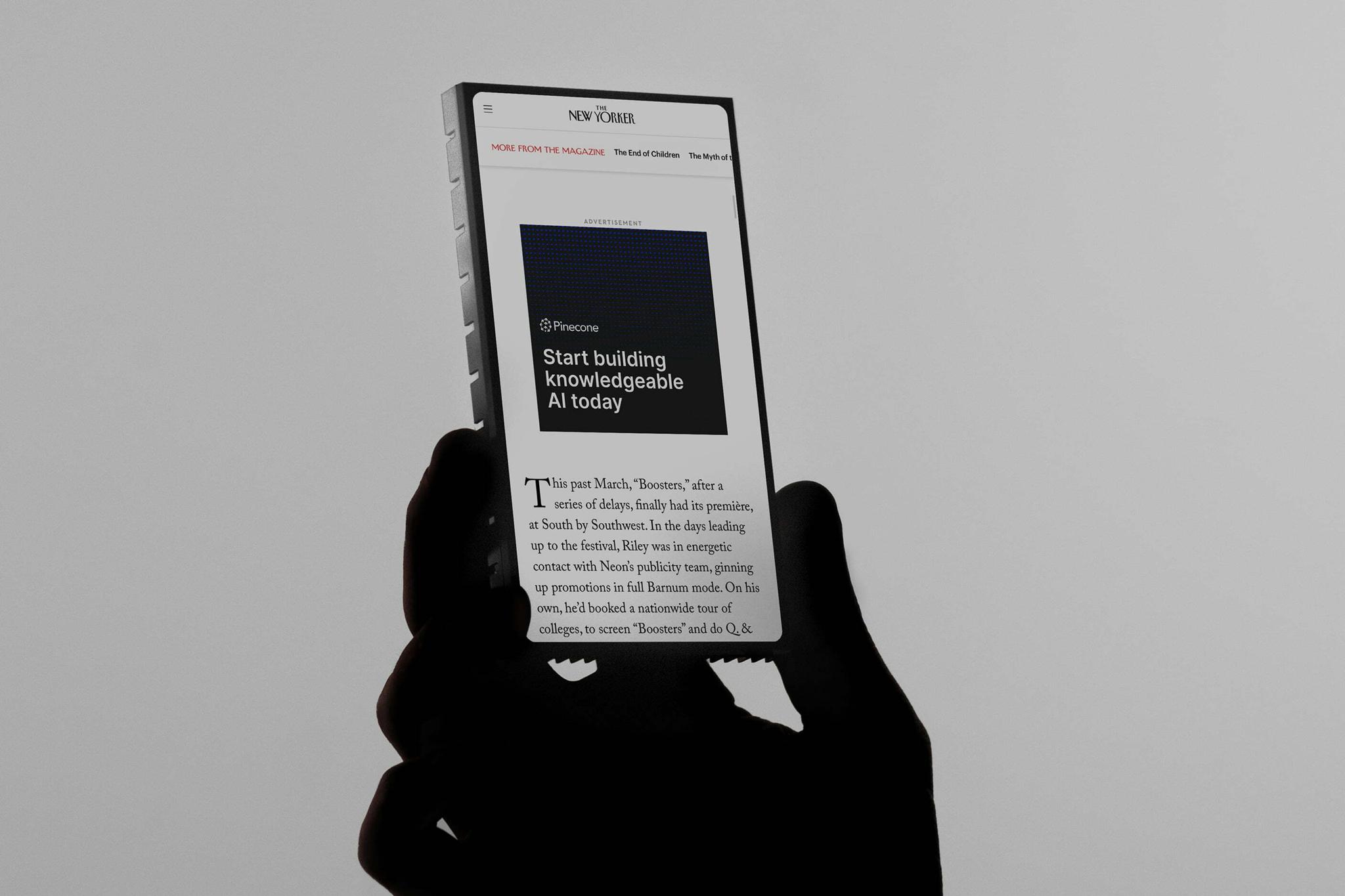 Hand holding an e-reader displaying a Pinecone advertisement in The New Yorker.