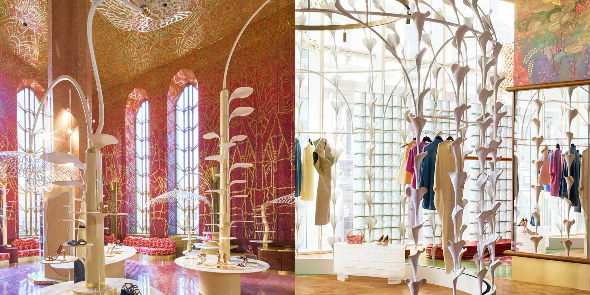 Boutique interior with tall arched windows, clothing racks, and white branch sculptures