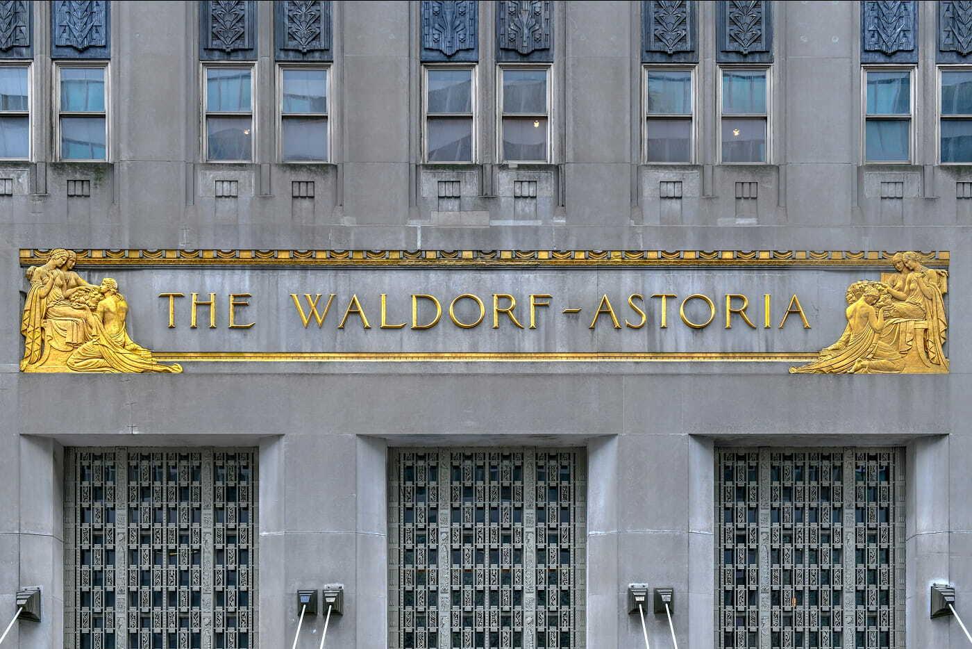 Gold The Waldorf Astoria sign on a gray building facade