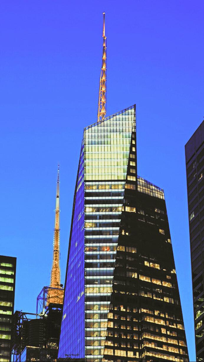 Modern skyscrapers and towers lit up against a twilight blue sky