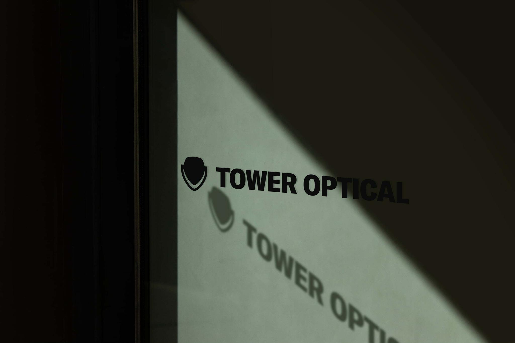 Tower Optical logo reflected on green-tinted glass