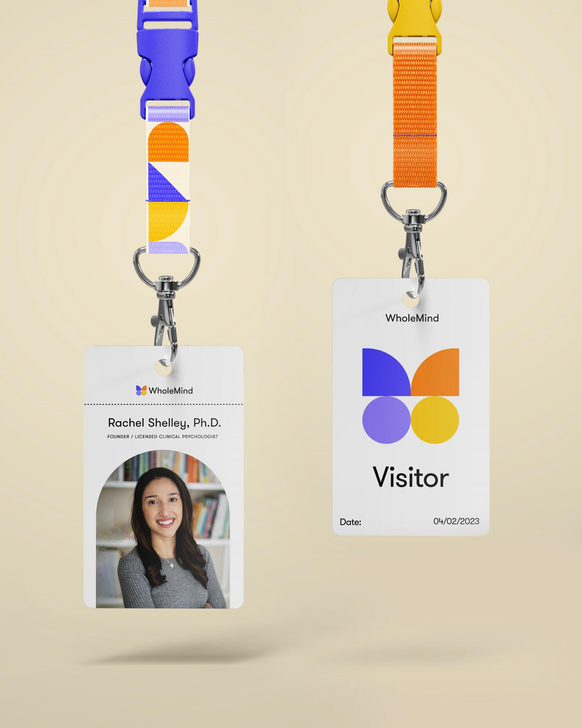 Two WholeMind lanyard badges, one staff ID and one visitor pass, with colorful straps