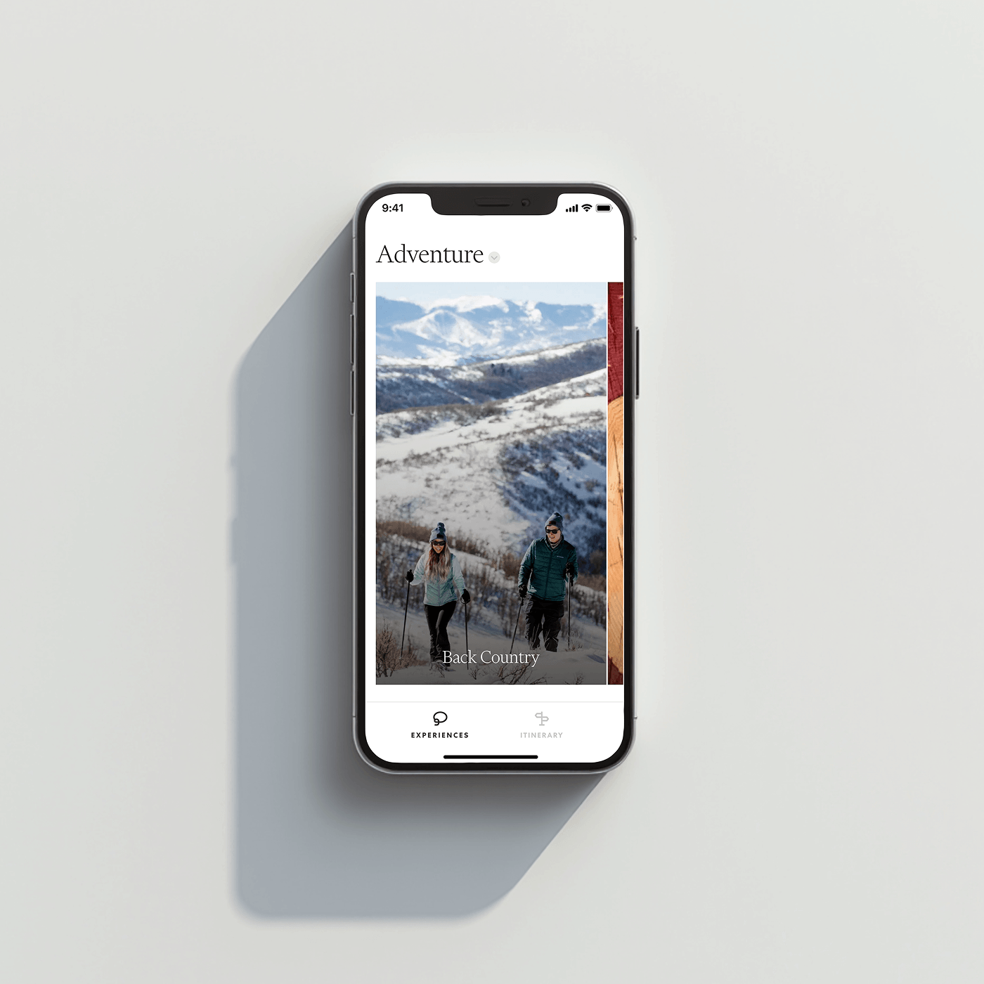 Smartphone showing an Adventure app screen with snowy backcountry scene
