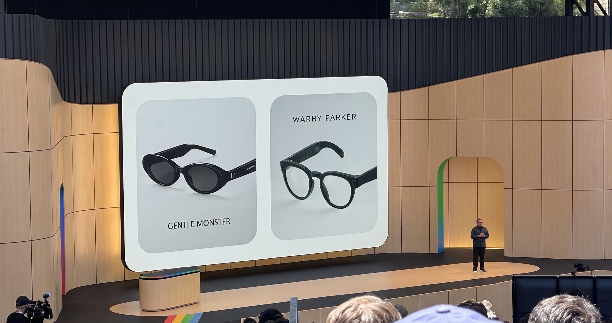 Conference stage showing smart glasses icons on a large screen