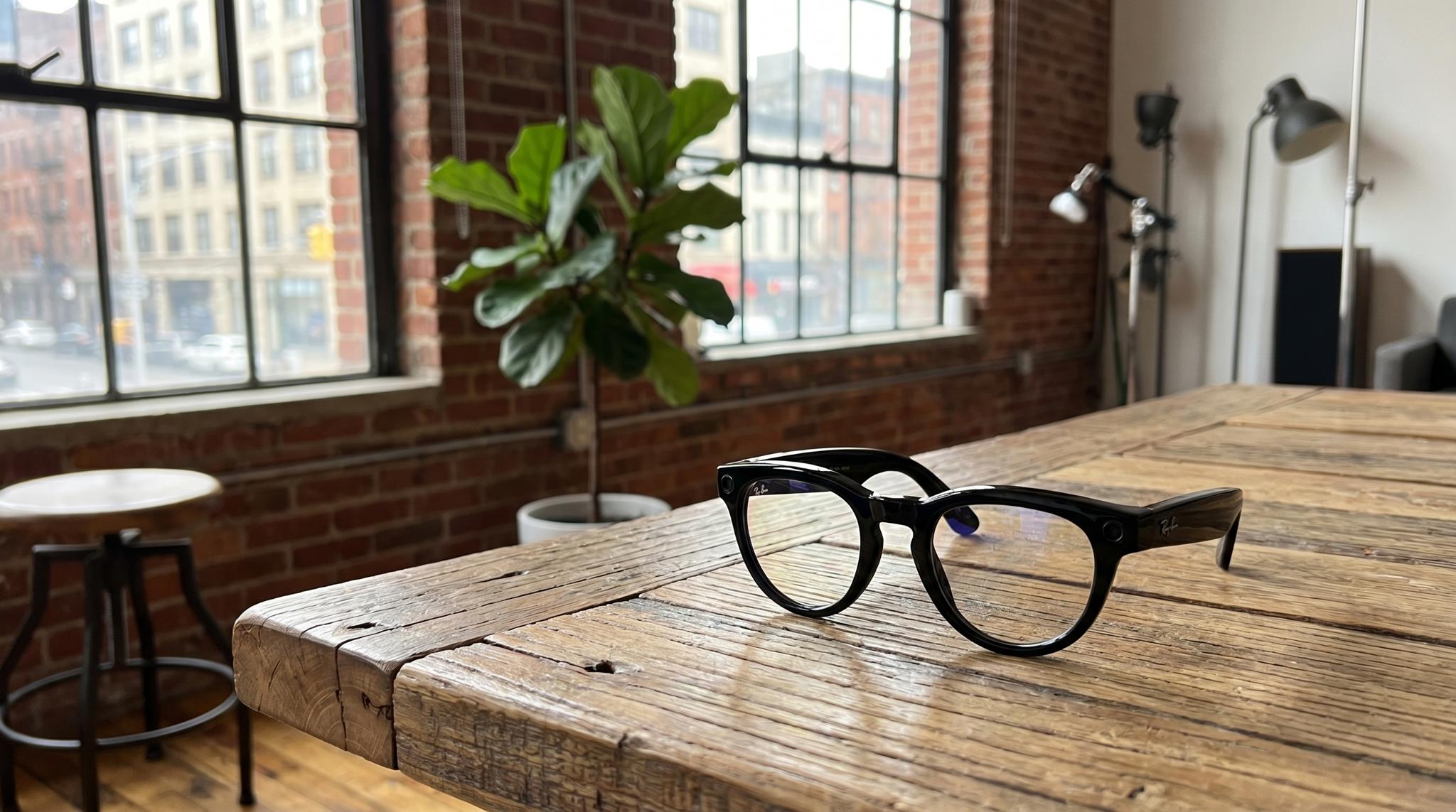 Ray-Ban Meta smart glasses on a wood table in a brick-walled Brooklyn studio