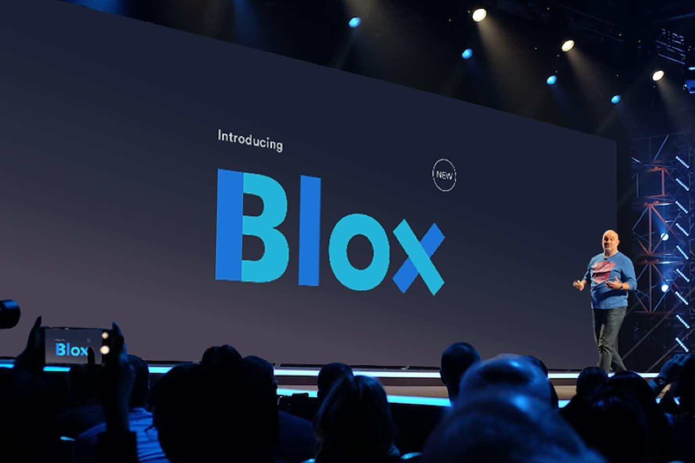 Conference stage introducing Blox with large blue wordmark on screen