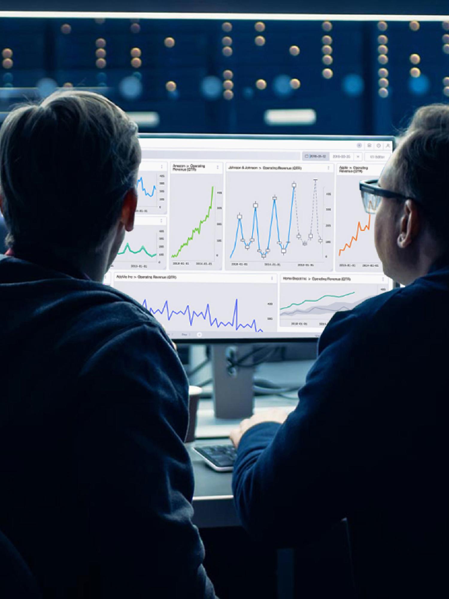 Two people viewing analytics dashboards on a large monitor