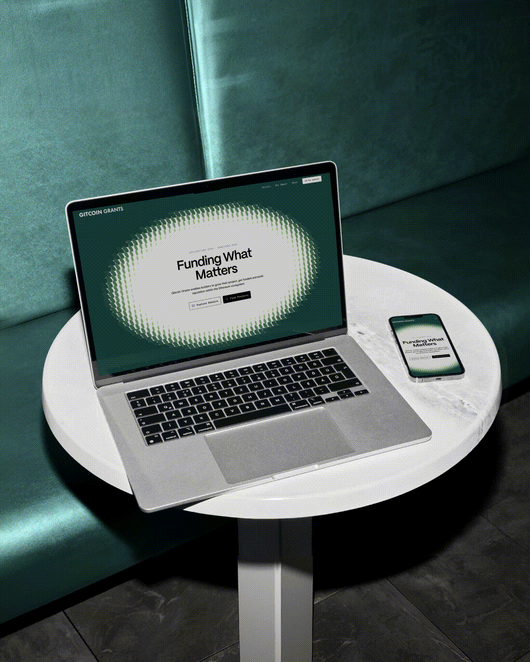 Laptop and phone on a round table show the Gitcoin Grants "Funding What Matters" page.