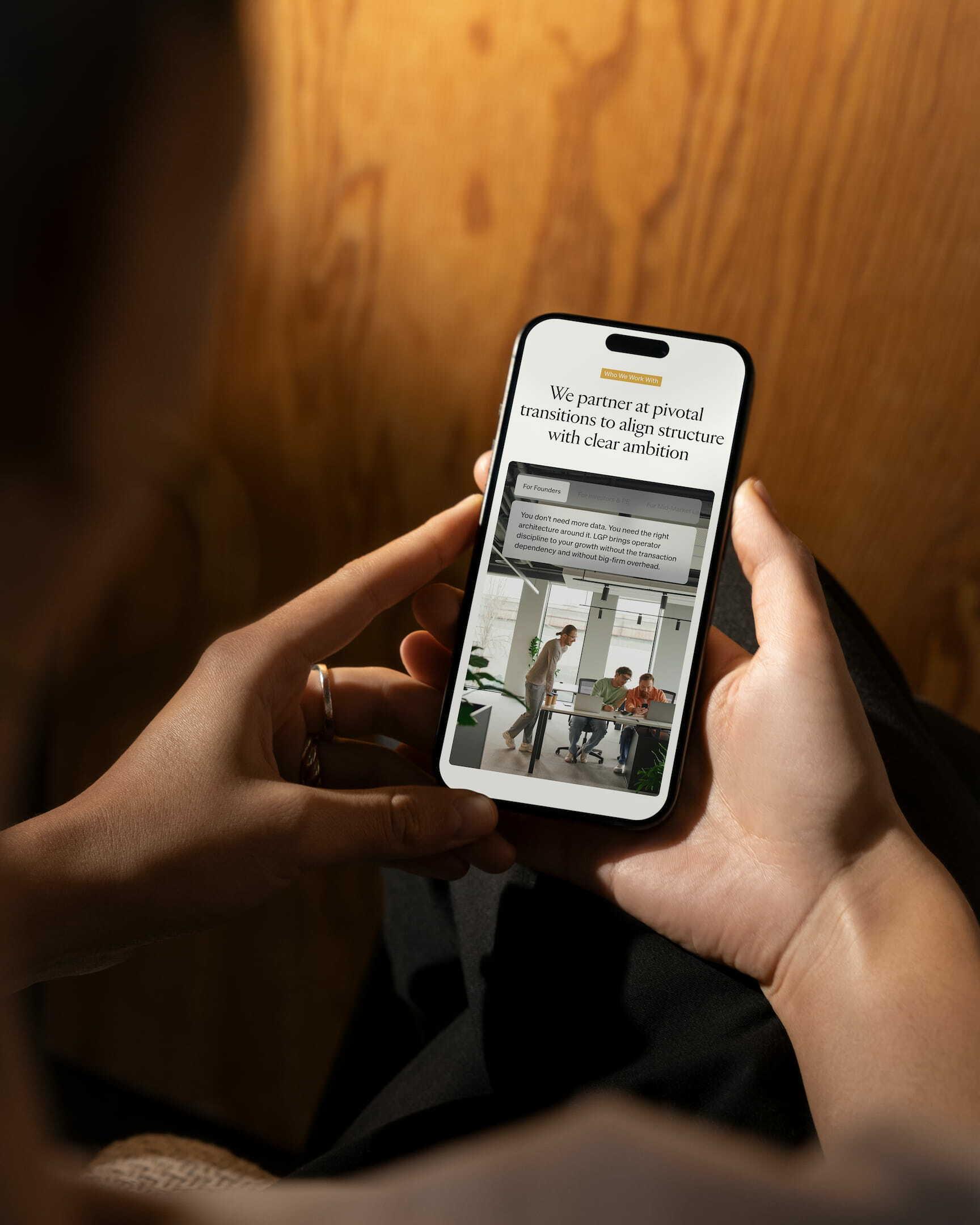 Hands holding a smartphone displaying the Levant Growth Partners mobile website