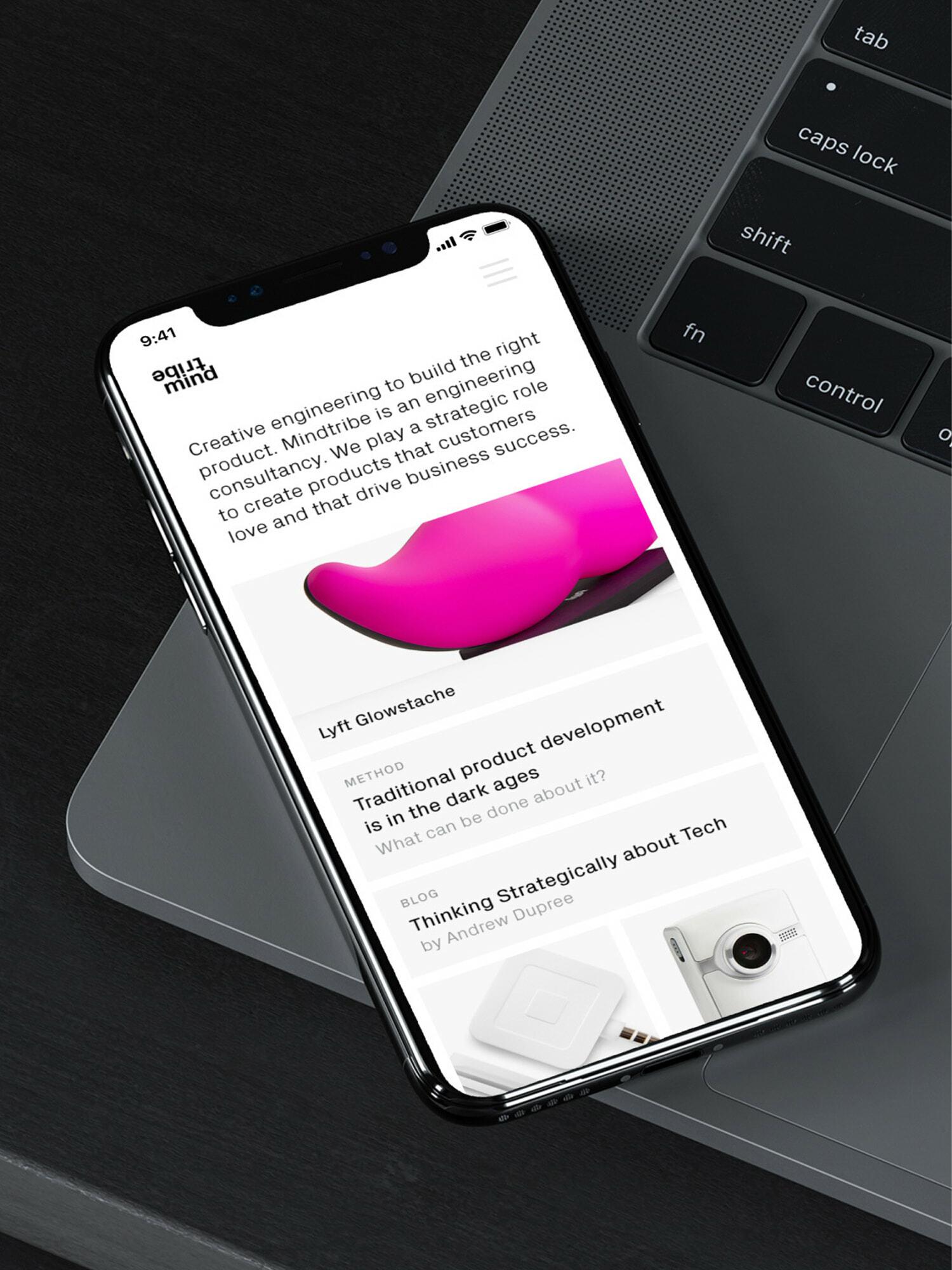 Phone on laptop showing a product design consultancy website