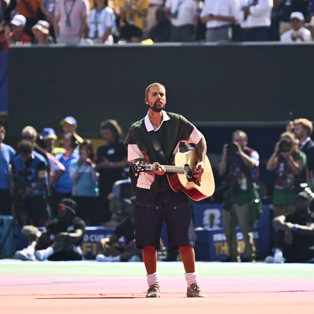 Athlete holding a ball on a sports court before spectators.