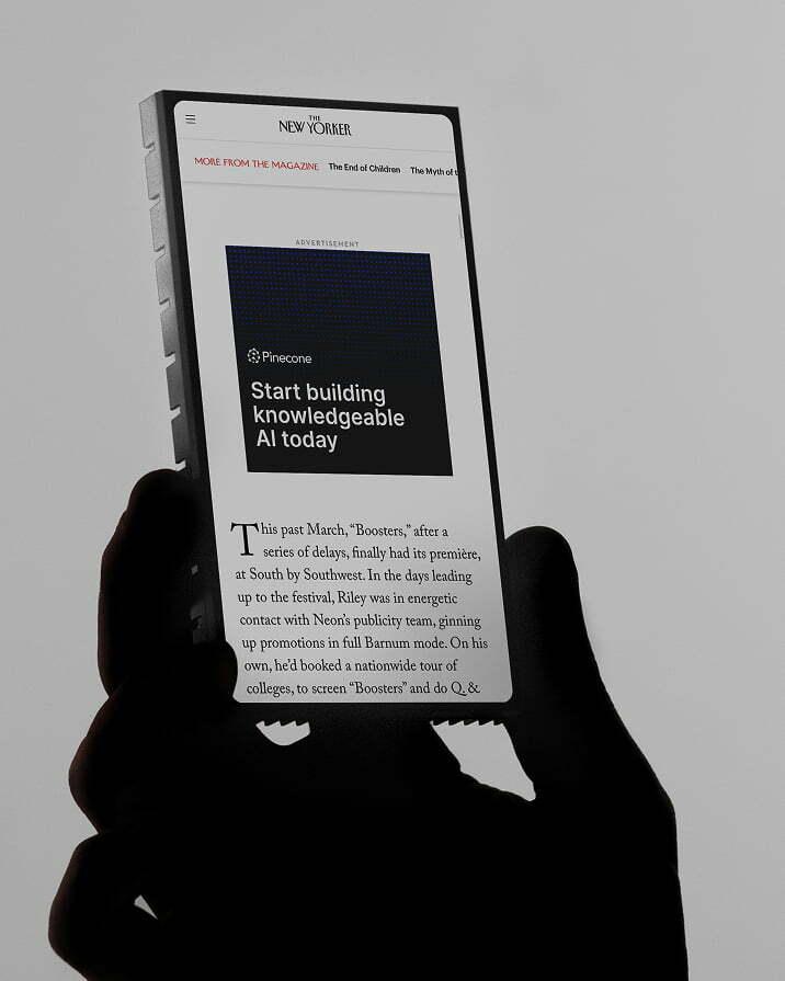 Hand holding an e-reader with a Pinecone ad above an article in The New Yorker.