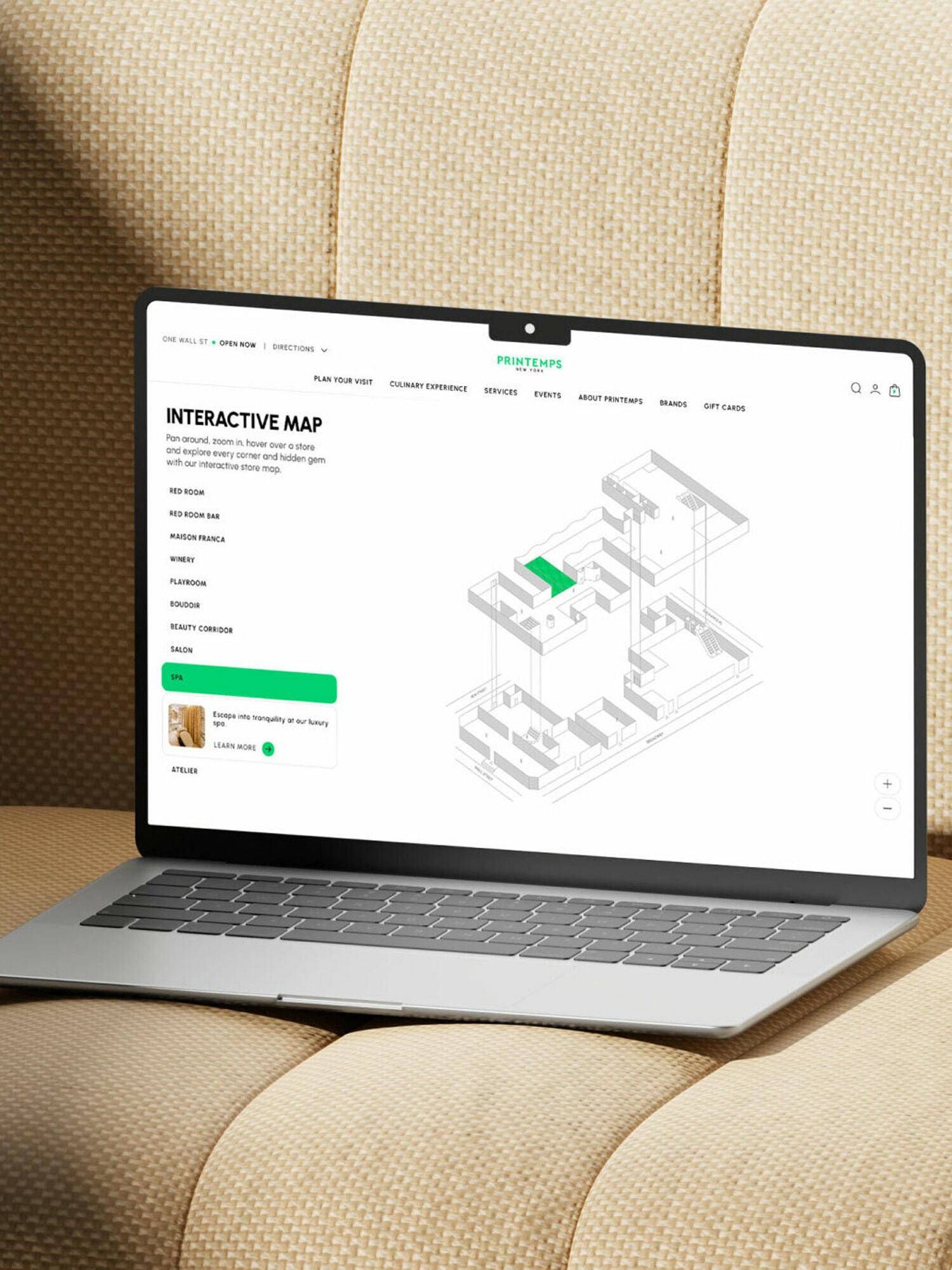 Laptop on beige couch displaying an interactive map webpage