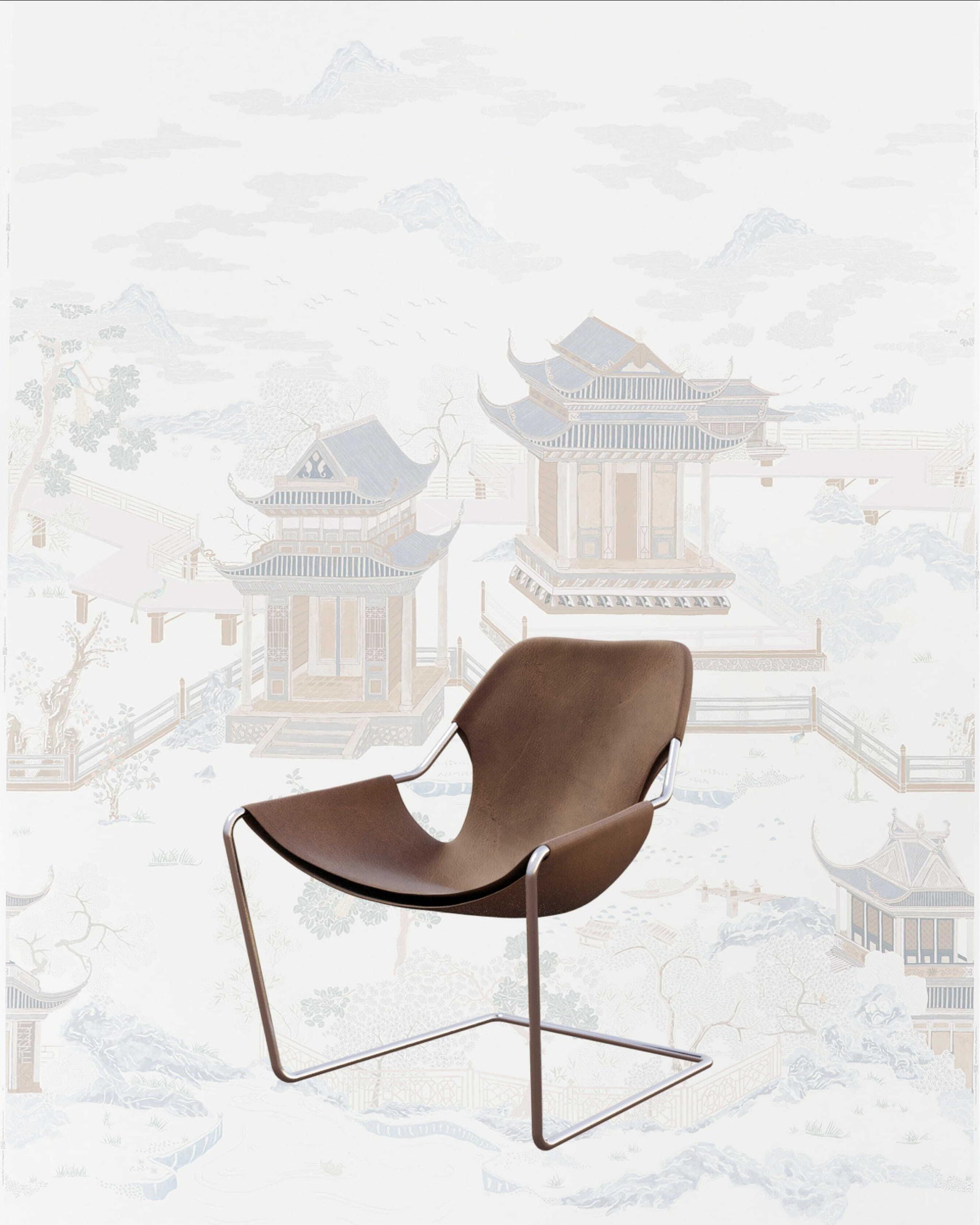 Brown sling lounge chair on a metal frame with pale Chinese landscape wallpaper behind