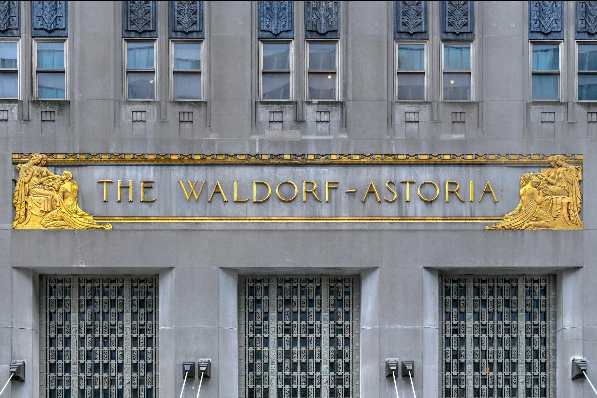 Gold The Waldorf Astoria sign on a gray building facade