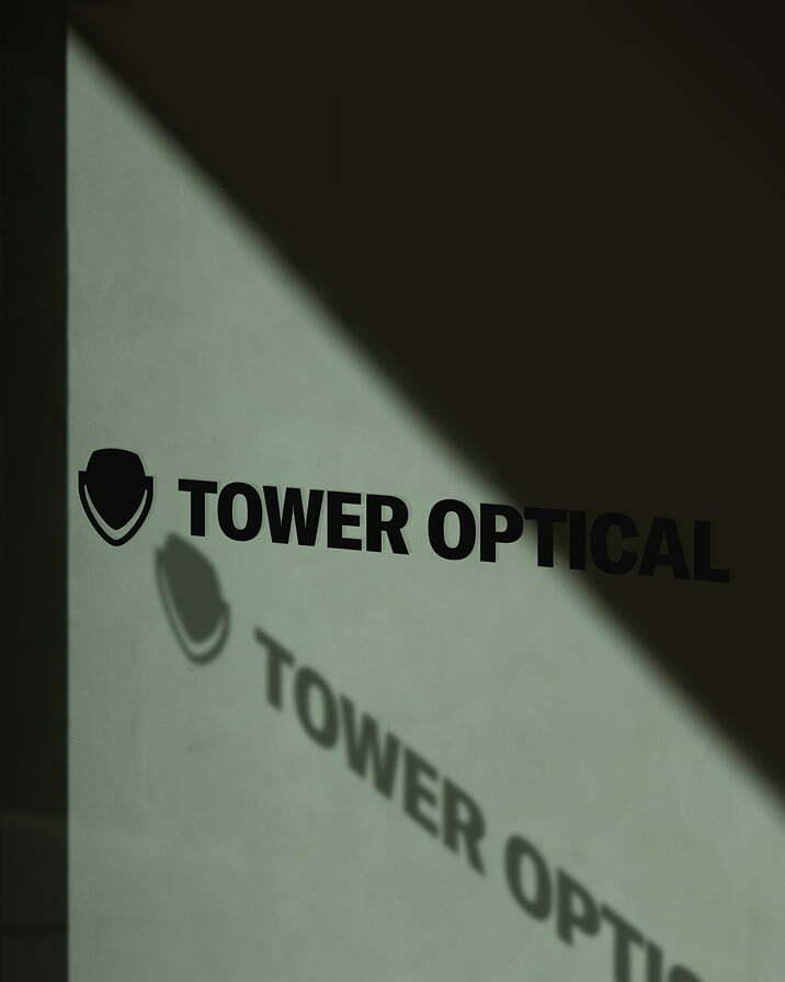 Close-up of Tower Optical logo on green-tinted glass