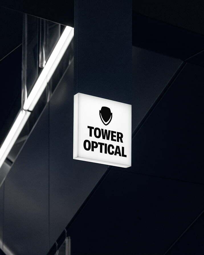 Illuminated Tower Optical sign mounted on a dark building exterior.